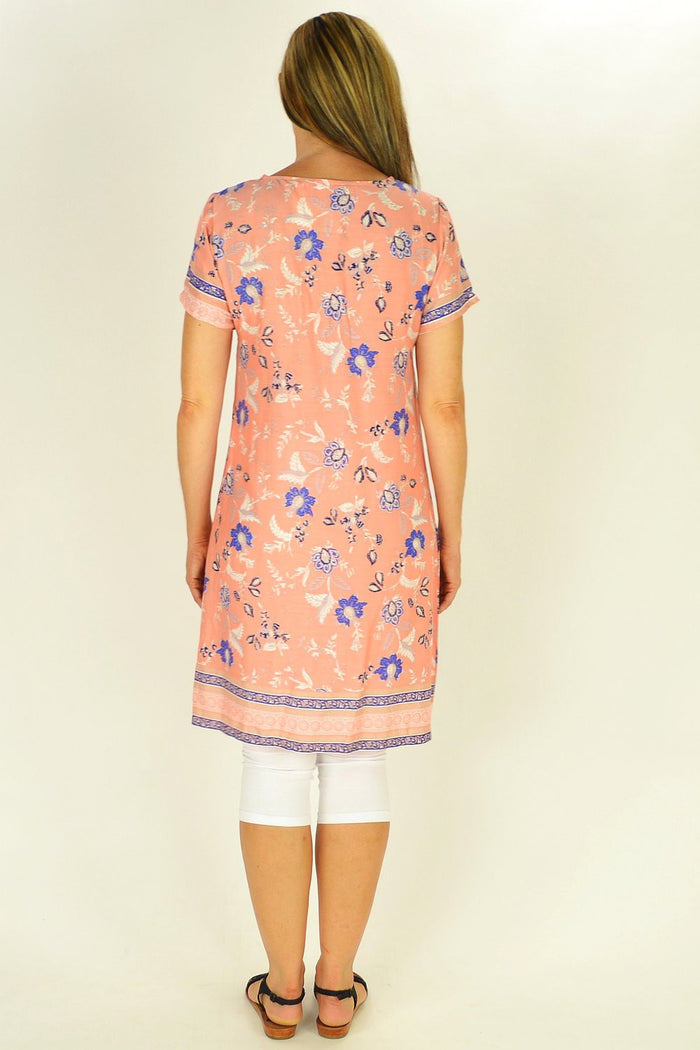 Apricot floral MSTYLE tunic displayed on a hanger, featuring a flowing fabric and vibrant floral pattern.
