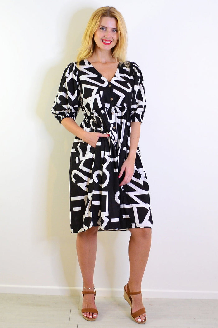 Black and white front button-up tunic dress by New U Collection featuring a relaxed fit and stylish collar detail.