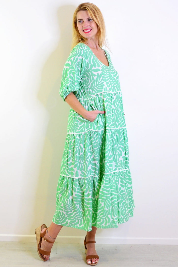 White and green tiered tunic dress by New U Collection, showing flowy fabric and layered design on a mannequin.