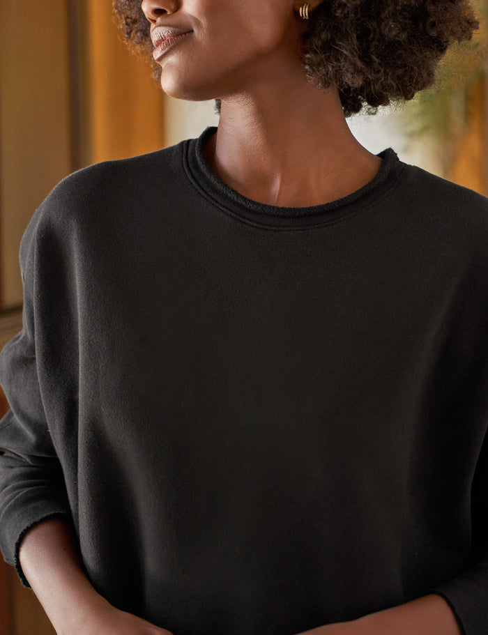 Person wearing a black sweater with a blurred background