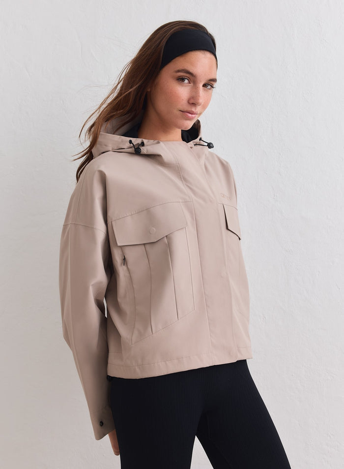 Dark Clay Waterproof Jacket cargotaskuilla ja hupulla aim'n-mallin päällä. [M-178cm]