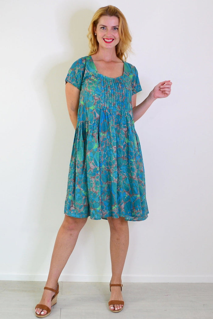 Emerald aqua abstract tunic dress by Wishstone featuring flowing fabric and vibrant pattern, displayed on a hanger.