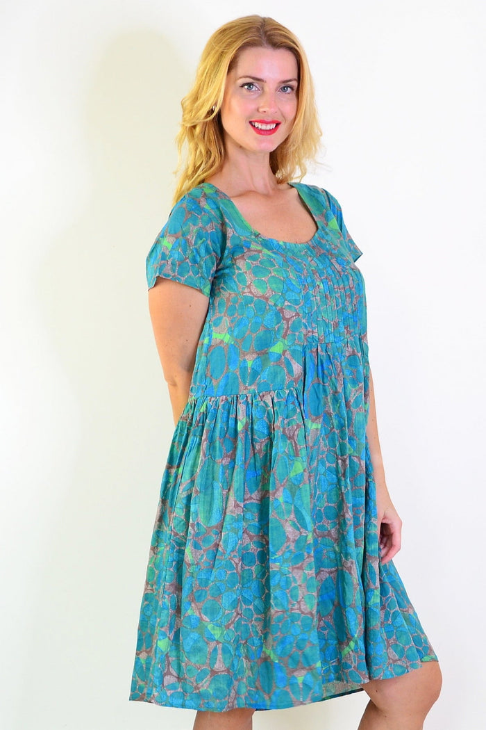 Wishstone emerald aqua abstract tunic dress displayed on a hanger, featuring vibrant colors and flowing fabric.