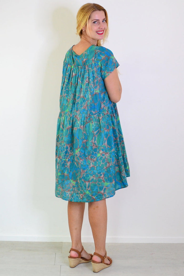 Emerald aqua abstract tunic dress by Wishstone, featuring flowing fabric and vibrant pattern, displayed on a mannequin.