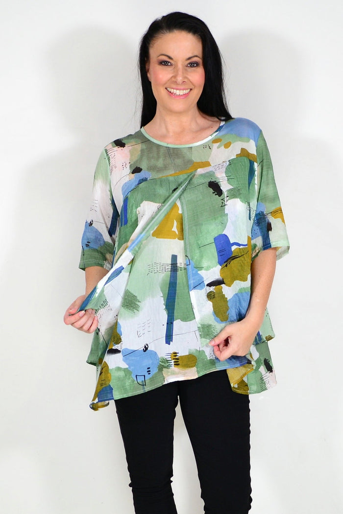 Green layered abstract tunic top by Whispers, featuring flowing fabric and artistic design, displayed on a neutral background.