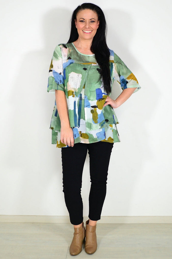 Green layered abstract tunic top by Whispers, featuring flowing fabric and artistic design, perfect for casual or dressy wear.