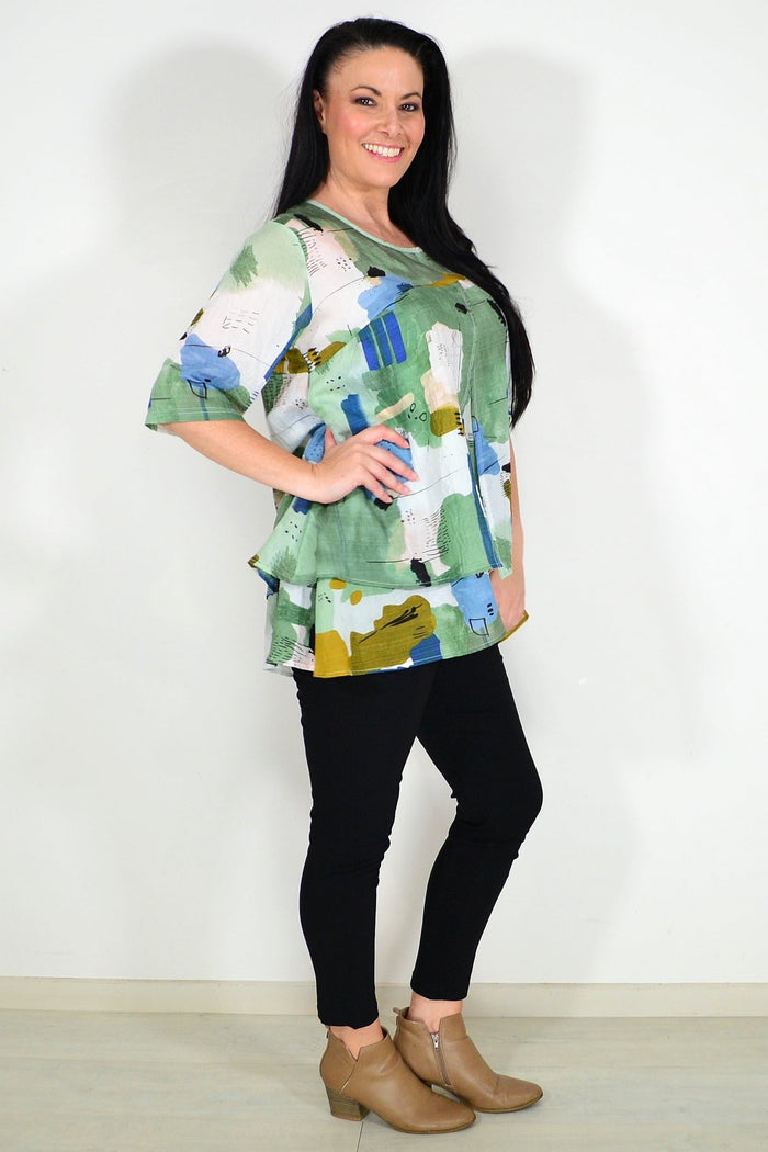 Green layered abstract tunic top by Whispers, featuring flowing fabric and artistic patterns, perfect for casual or stylish wear.