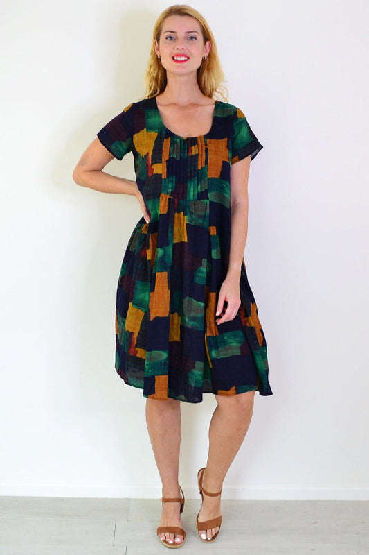 Wishstone mustard olive abstract tunic dress displayed on a mannequin, showcasing its stylish design and vibrant pattern.