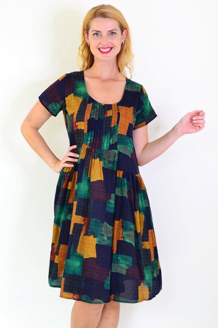 Wishstone mustard olive abstract tunic dress displayed on a hanger, showcasing its vibrant colors and relaxed fit.