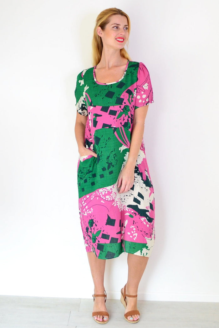 Pink and green paint splash tunic dress by Wishstone, featuring a flowy fabric and artistic design, displayed on a hanger.