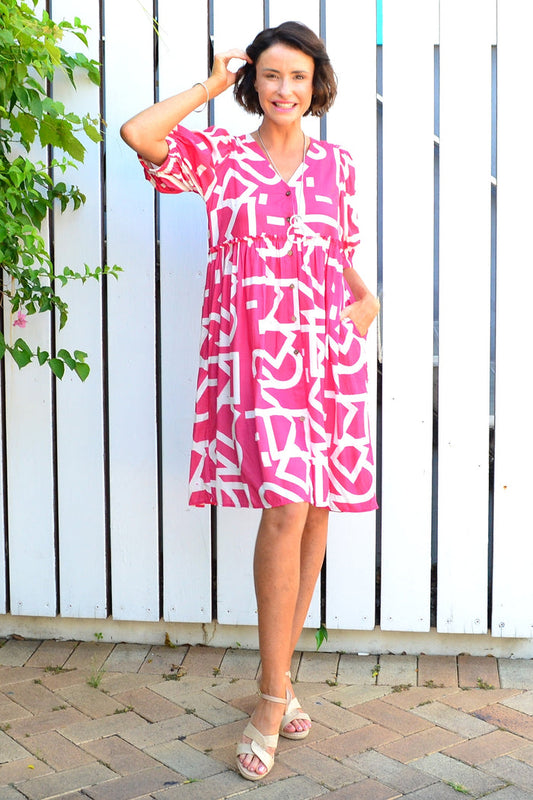 Pink and white front button-up tunic dress from New U Collection, featuring a stylish, casual design with a collar and long sleeves.