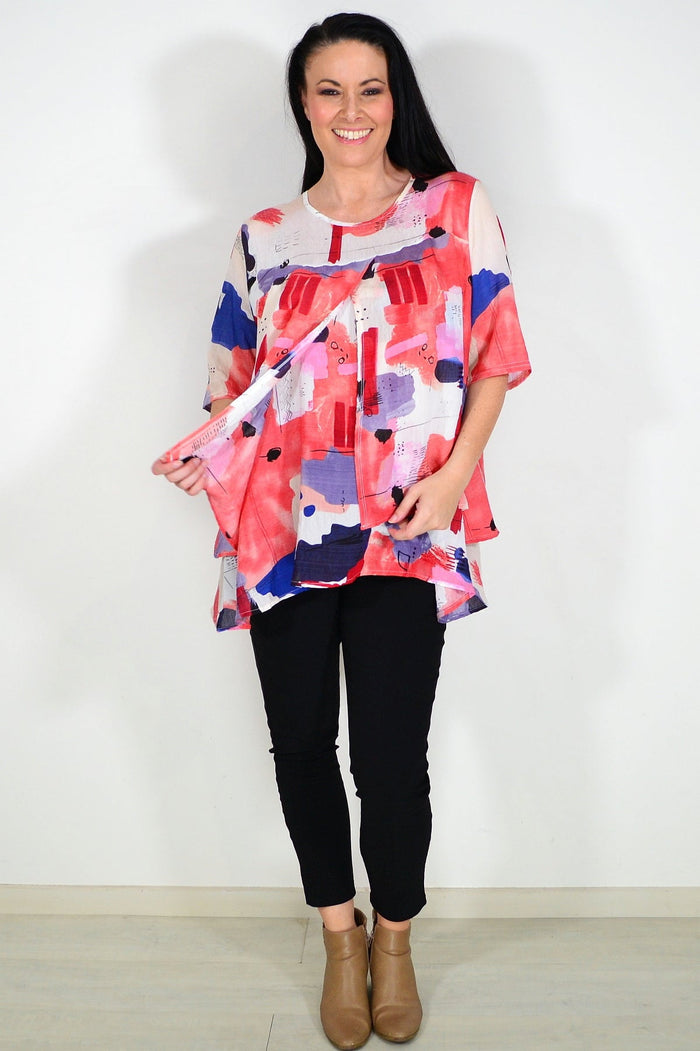 Red layered abstract tunic top by Whispers, featuring a flowing design and vibrant pattern, shown on a mannequin.